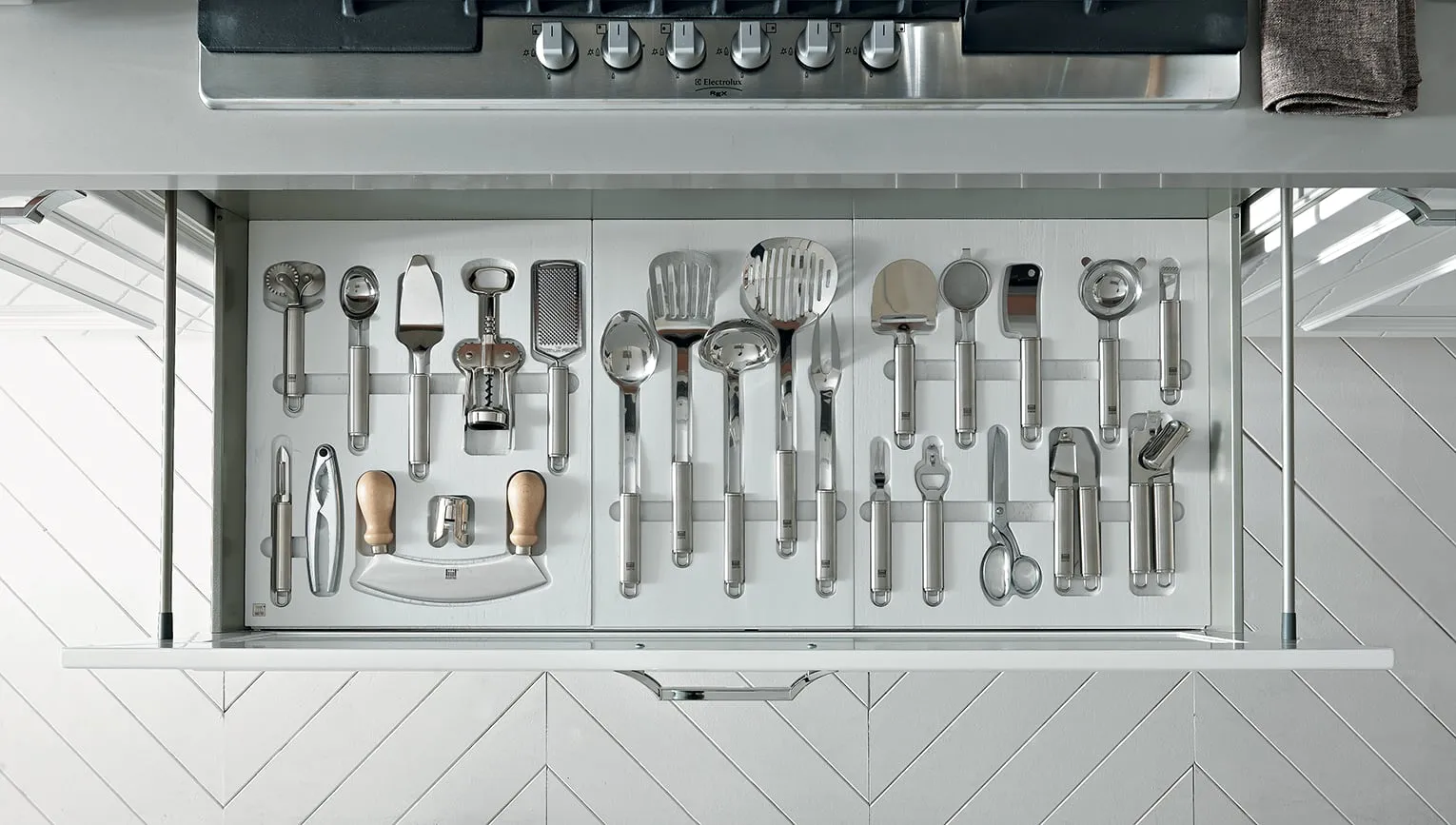Utensili da cucina appesi a una barra sopra il piano di lavoro