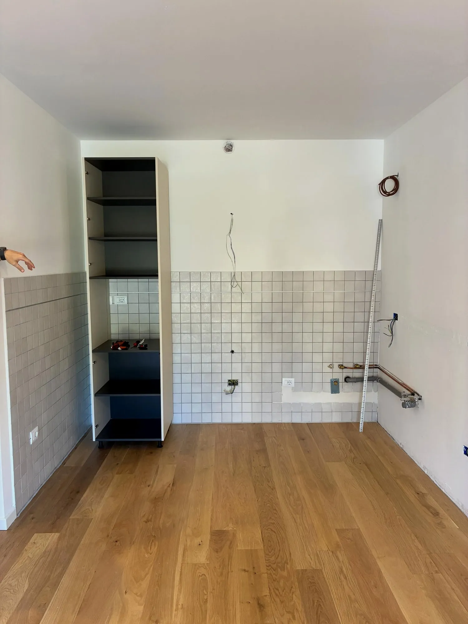 La stanza prima: parquet posato, piastrelle vecchie a mezza parete e una nicchia aperta